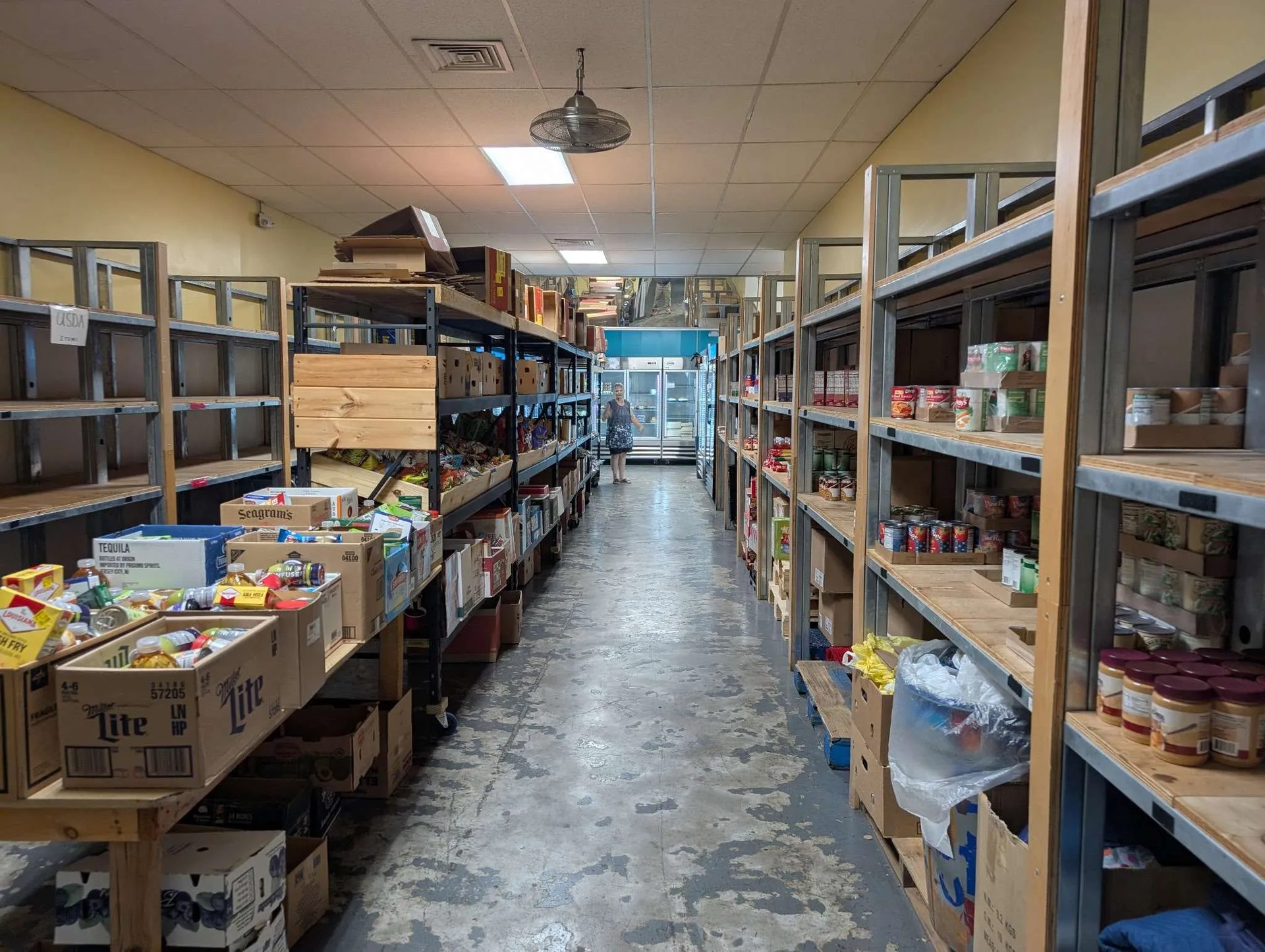 The main pantry aisle, shelves stocked with tinned and dry goods